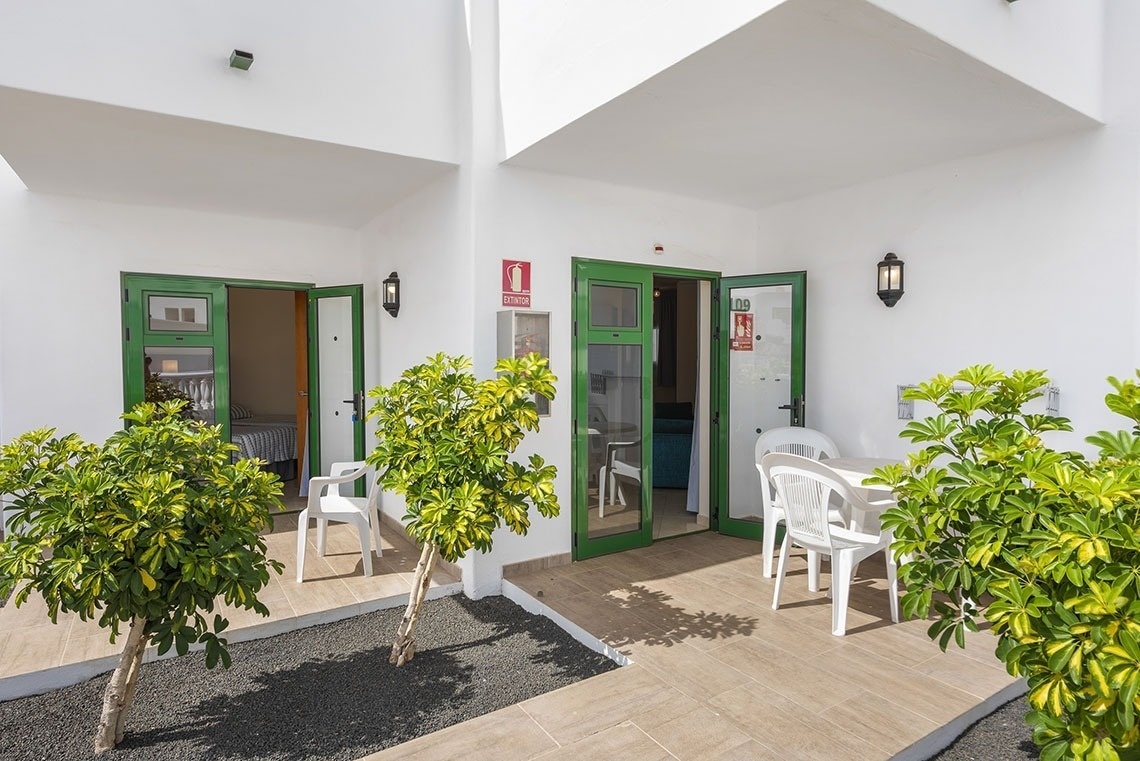 ein weißes Haus mit grünen Türen und weißen Möbeln