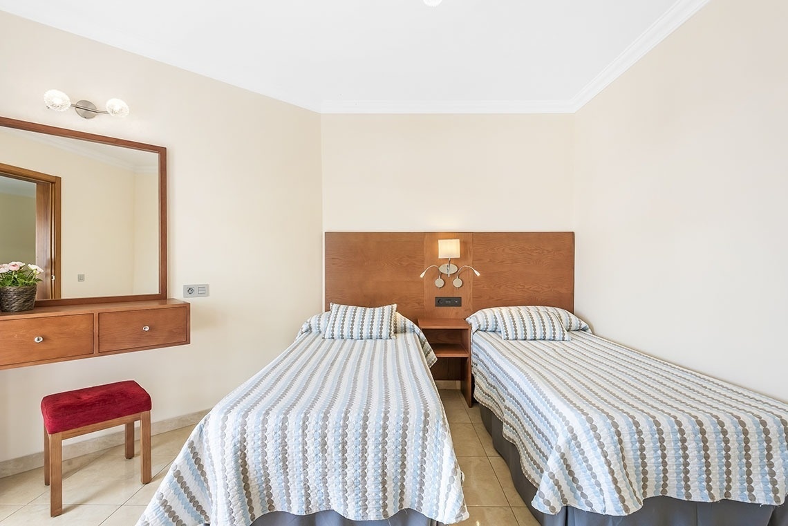 ein Schlafzimmer mit zwei Einzelbetten und einem Spiegel