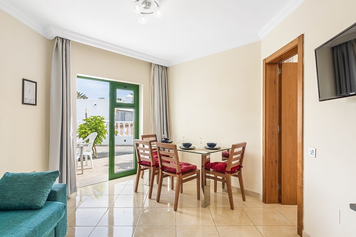 ein Balkon mit einem Schaukelstuhl und einem Tisch und einem Regenschirm