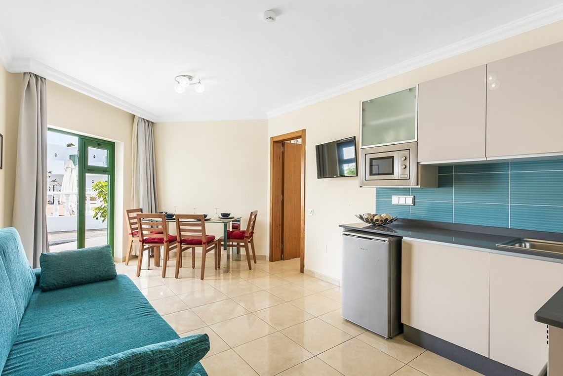 ein Wohnzimmer mit einer blauen Couch und einer Küche