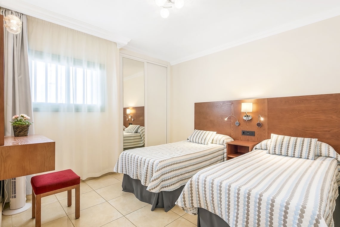 ein Schlafzimmer mit zwei Einzelbetten und einem Stuhl