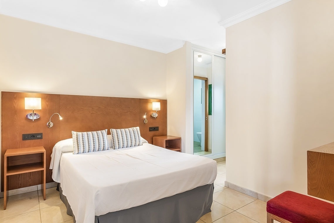 ein Hotelzimmer mit einem Bett und zwei Nachttischen