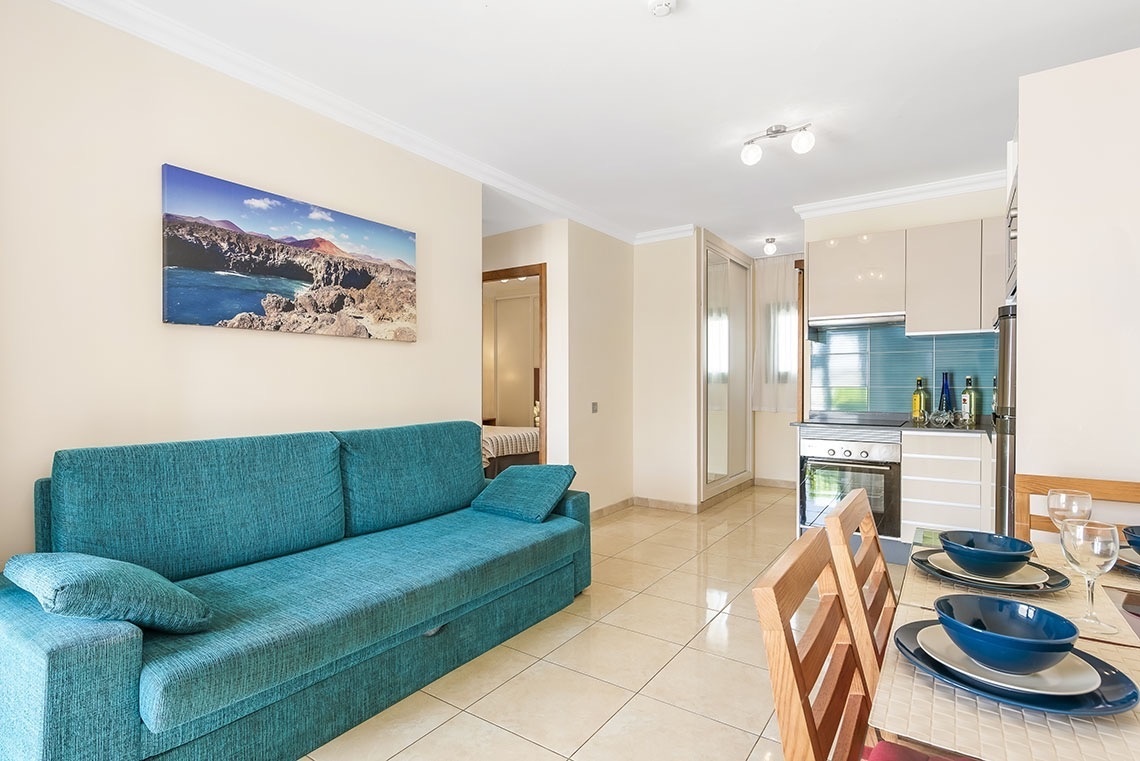 ein Wohnzimmer mit einer blauen Couch und einem Gemälde an der Wand