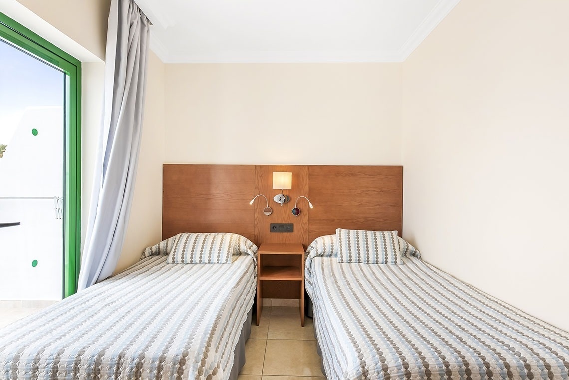 ein Schlafzimmer mit zwei Einzelbetten und einem Nachttisch