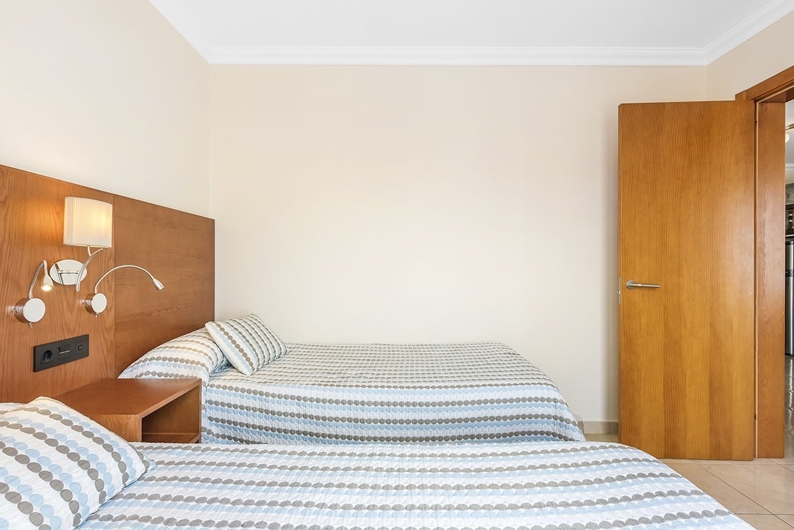 ein Schlafzimmer mit zwei Betten und einem Nachttisch