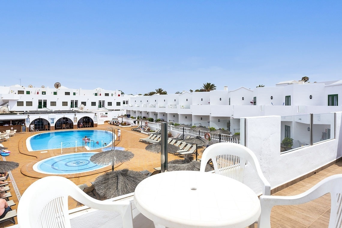 ein weißer Tisch und Stühle stehen in der Nähe eines Swimmingpools