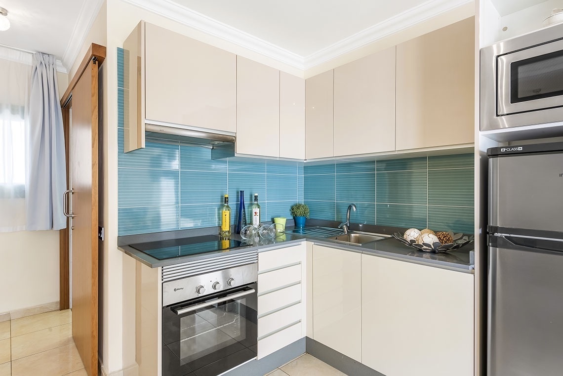 eine kleine Küche mit einem Kühlschrank und einem Mikrowellenherd