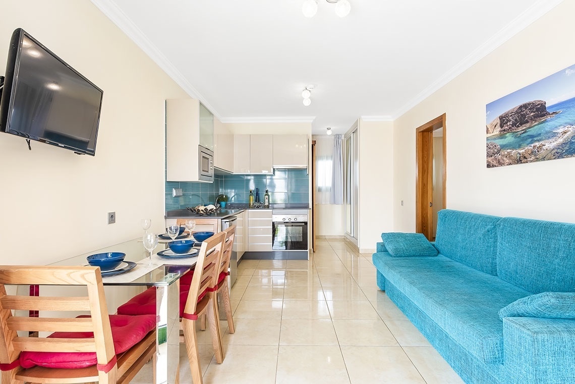 ein Wohnzimmer mit einer blauen Couch und einem Fernseher