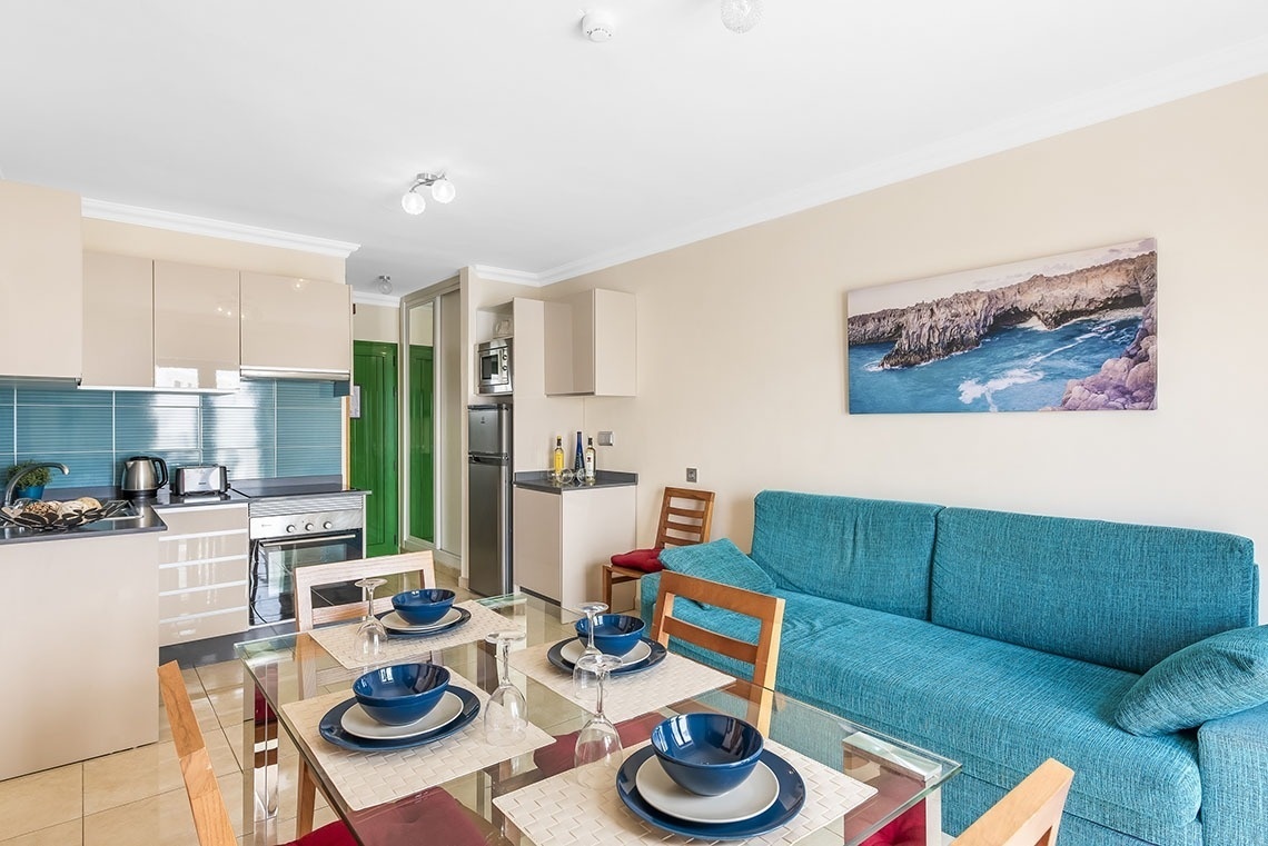 ein Wohnzimmer mit einem Tisch und Stühlen und einem Bild an der Wand