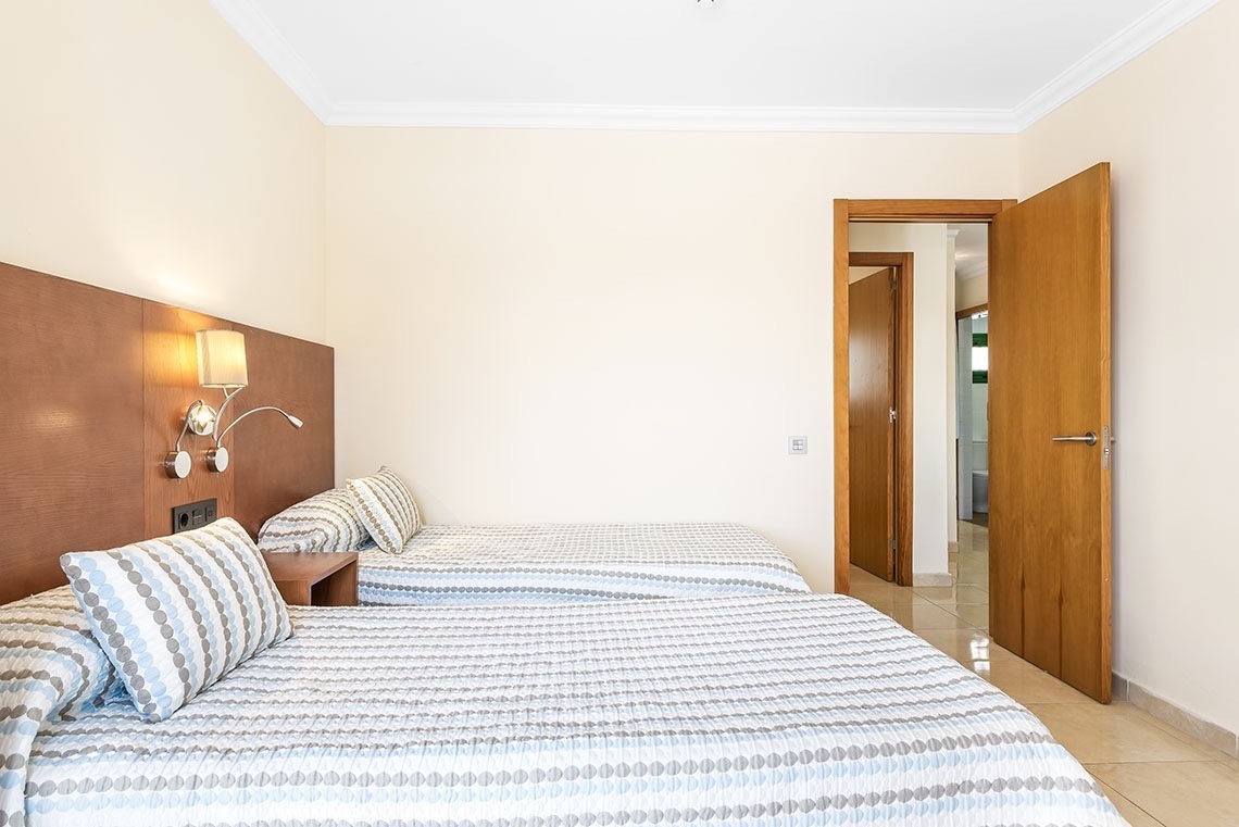 ein Schlafzimmer mit zwei Betten und einer Tür