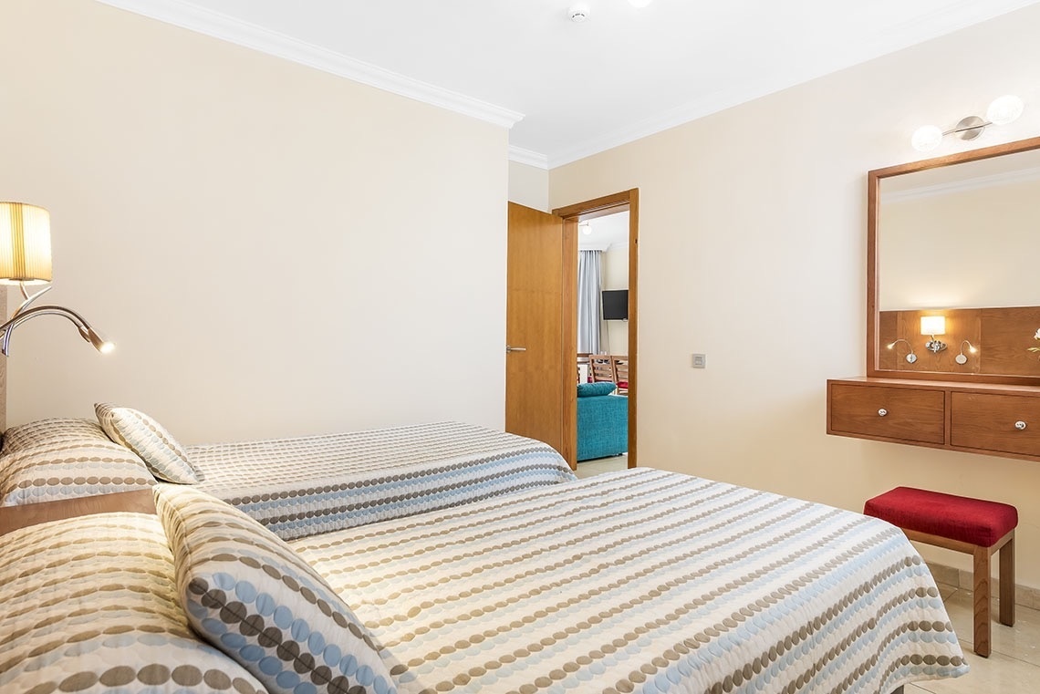 ein Schlafzimmer mit zwei Betten und einem Spiegel