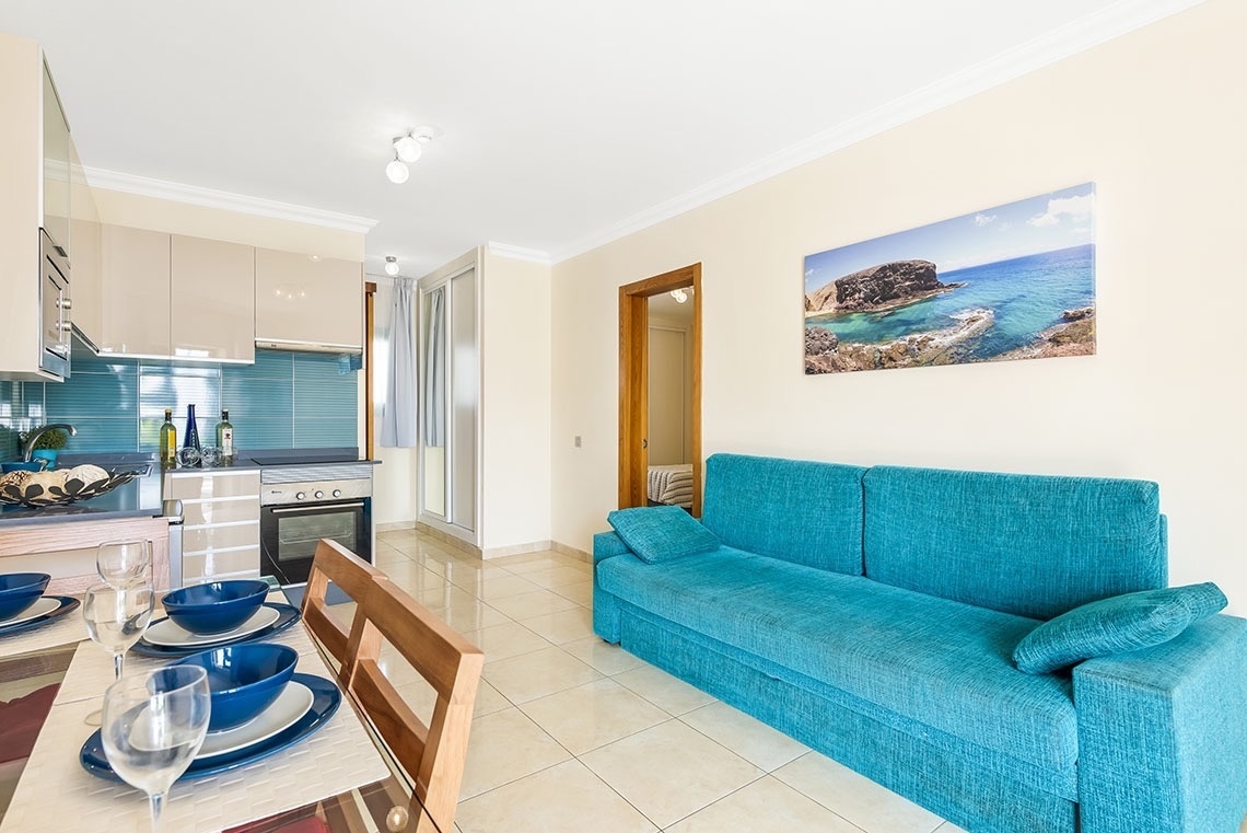 ein Wohnzimmer mit einem blauen Couch und einem Gemälde an der Wand