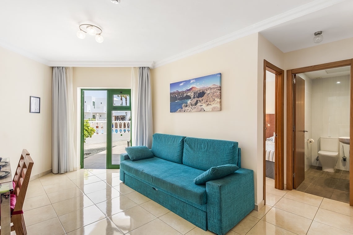 ein Wohnzimmer mit einer blauen Couch und einem Gemälde an der Wand