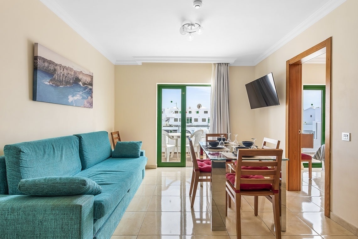 ein Wohnzimmer mit einer blauen Couch und einem Fernseher