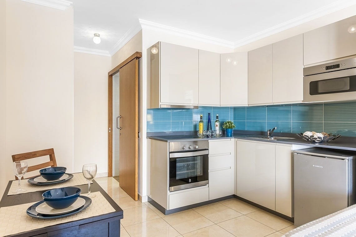 eine Küche mit weißen Schränken und einem samsung Kühlschrank