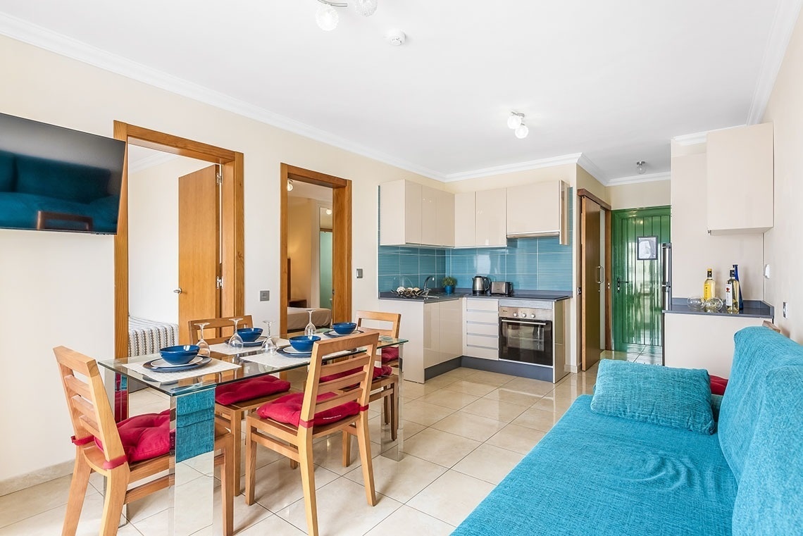 ein Wohnzimmer mit einem blauen Couchtisch und Stühlen