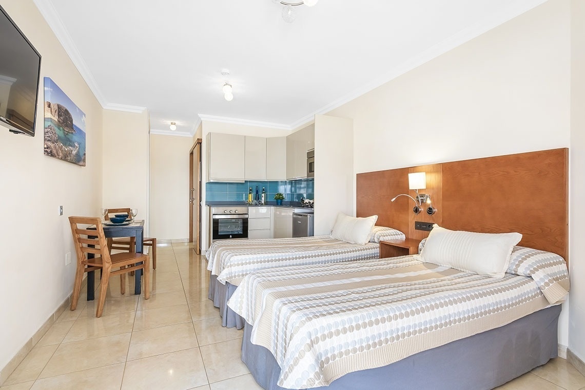 ein Schlafzimmer mit zwei Betten und einem Fernseher