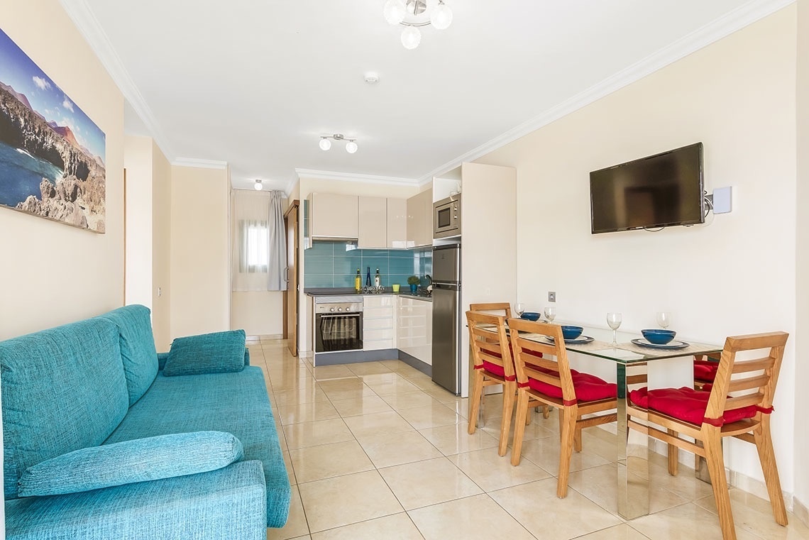 ein Wohnzimmer mit einer blauen Couch und einem Fernseher