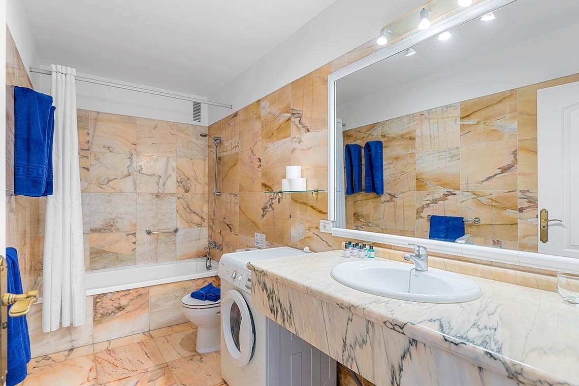 une salle de bain avec un lavabo et une machine à laver