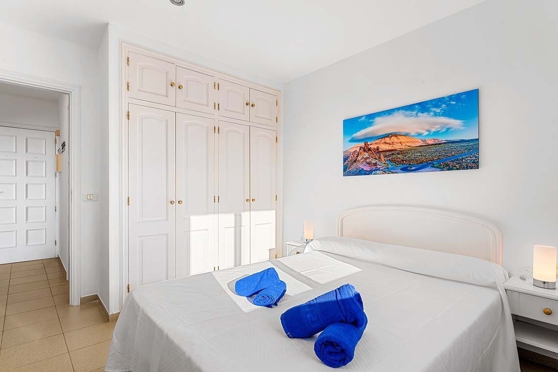 une chambre avec un lit et une peinture sur le mur