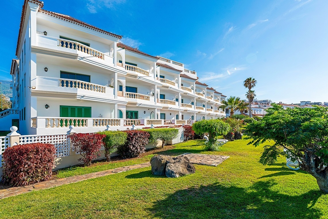 a swimming pool with two lounge chairs and an umbrella