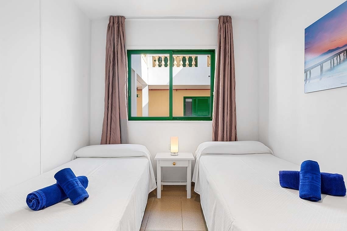 une chambre avec deux lits , une table et une fenêtre