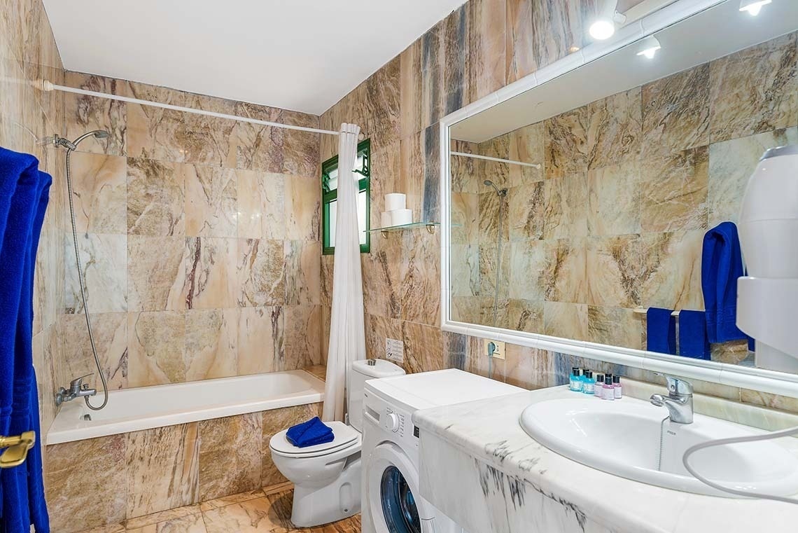 une salle de bain avec un lavabo et une machine à laver