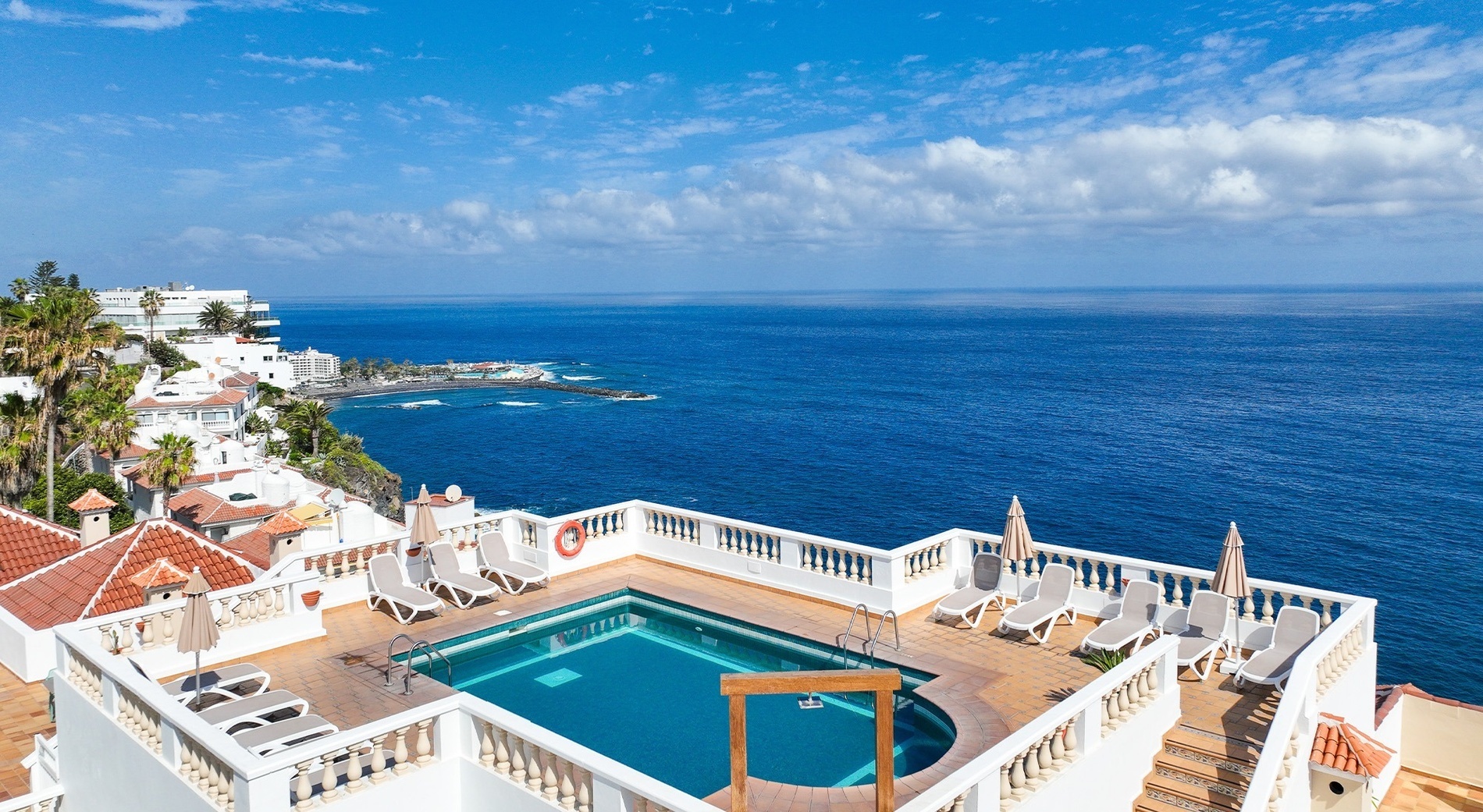 un balcón con sillas y hamaca al atardecer