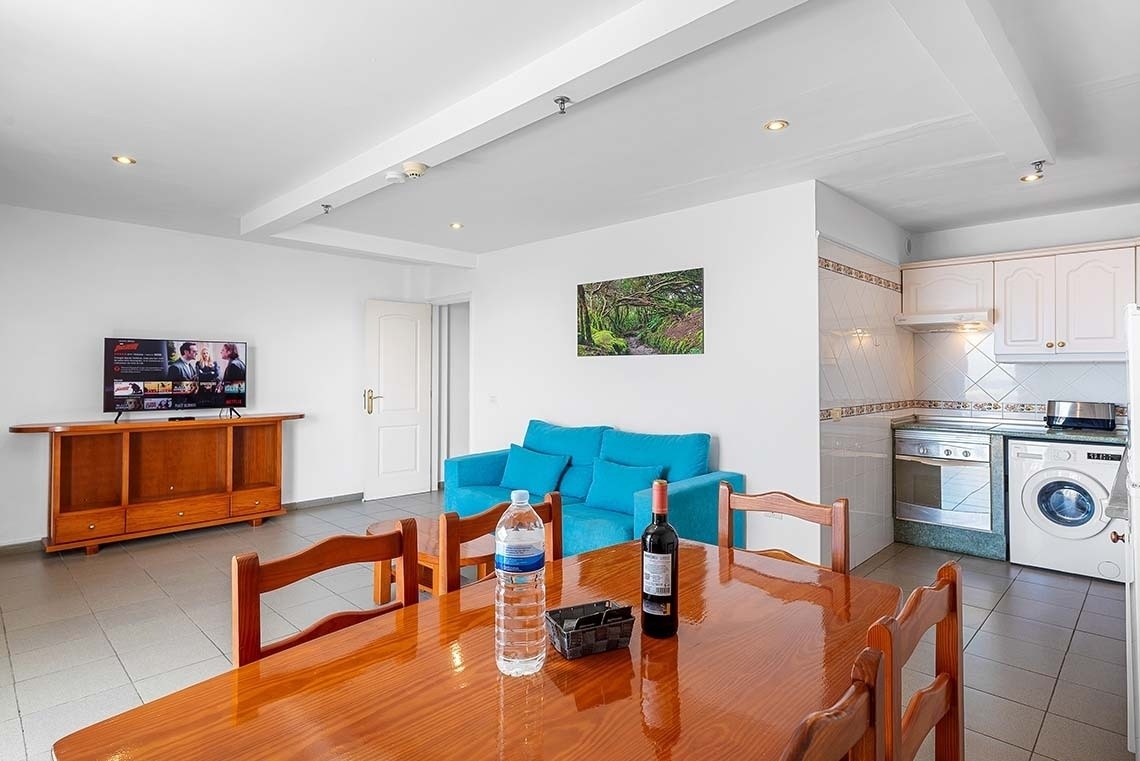 une salle à manger avec une télévision à écran plat et un canapé bleu