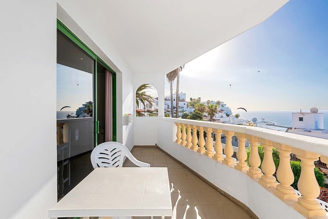 un hamac avec des serviettes et un parasol sur une terrasse avec vue sur l' océan