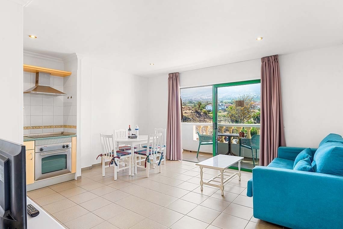 un salon avec un canapé bleu et une télévision