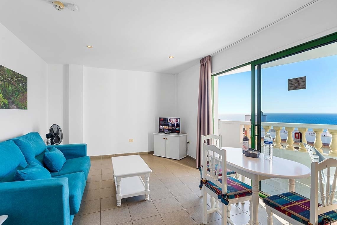 un salon avec un canapé bleu et une télévision