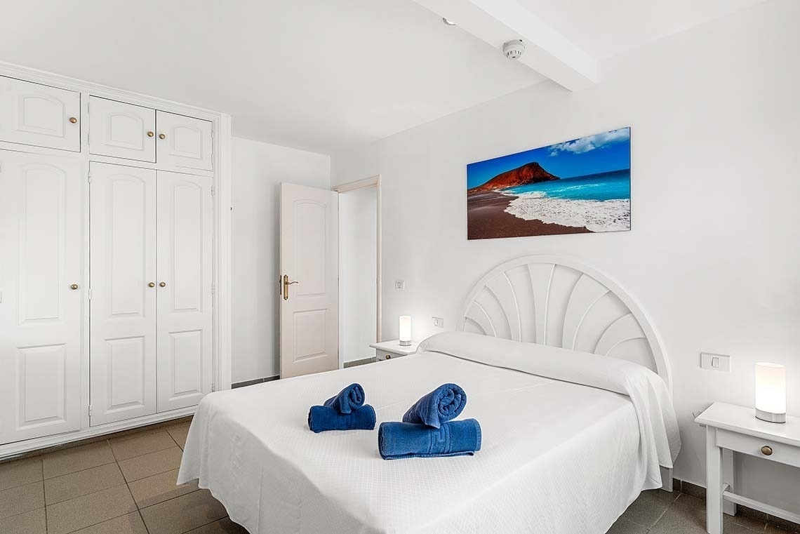 une peinture d' une plage est accrochée au mur de la chambre