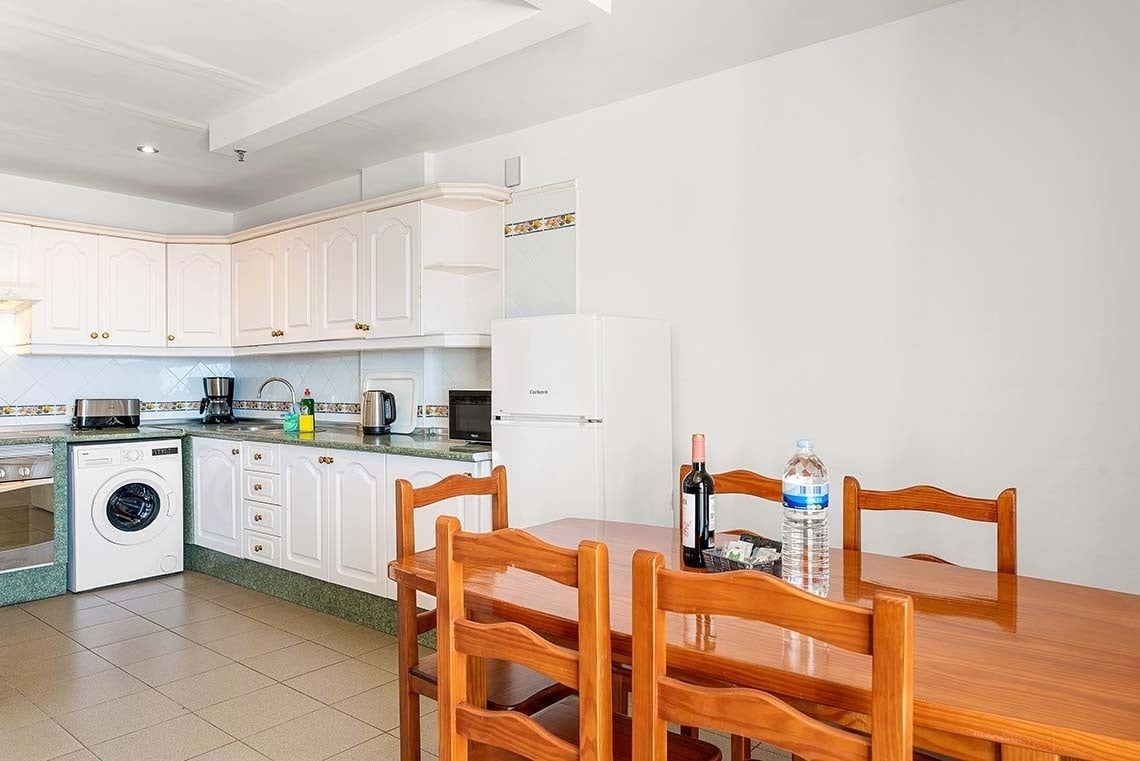 une cuisine avec une table et des chaises et une bouteille d' eau