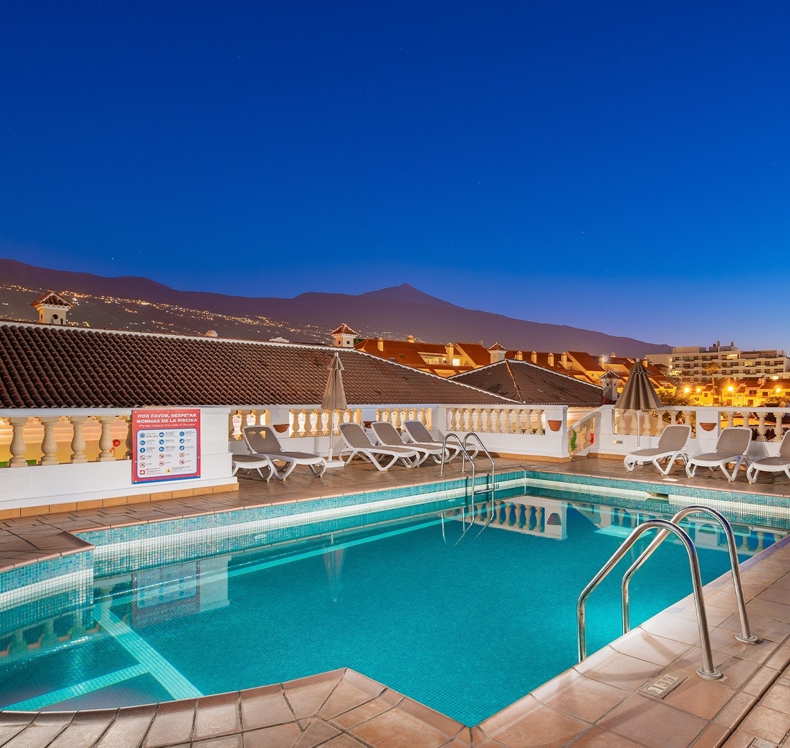 una piscina rodeada de muebles y una sombrilla