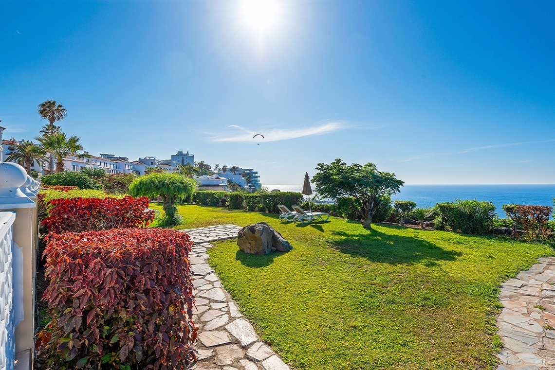 a large swimming pool with chairs and umbrellas around it