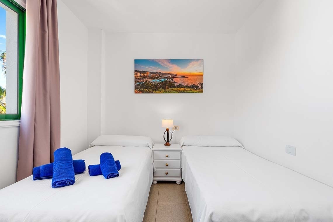 une chambre avec deux lits et une peinture sur le mur