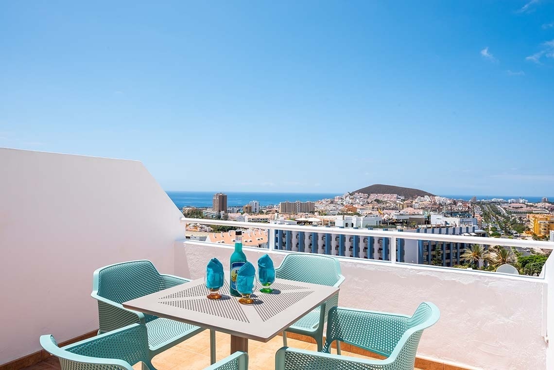 a balcony with a view of a city and the ocean