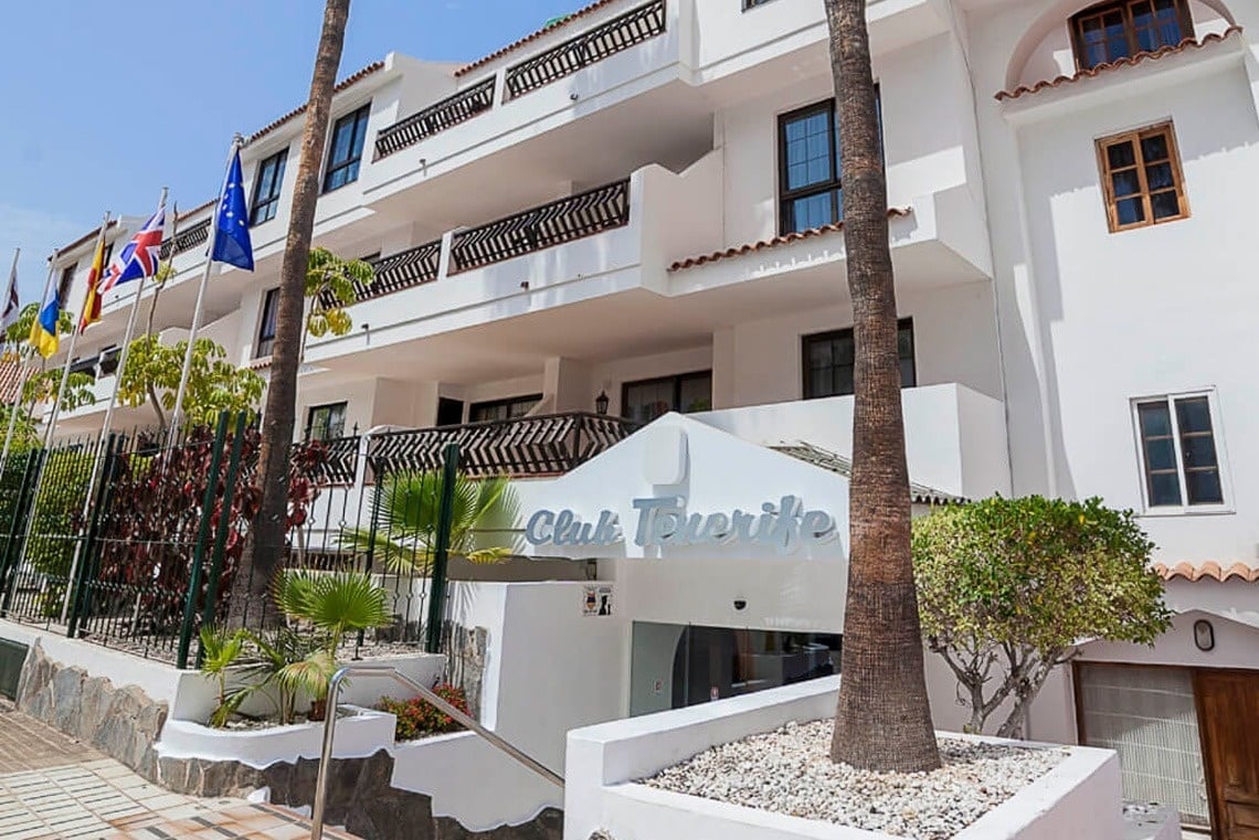 a swimming pool with two lounge chairs and an umbrella