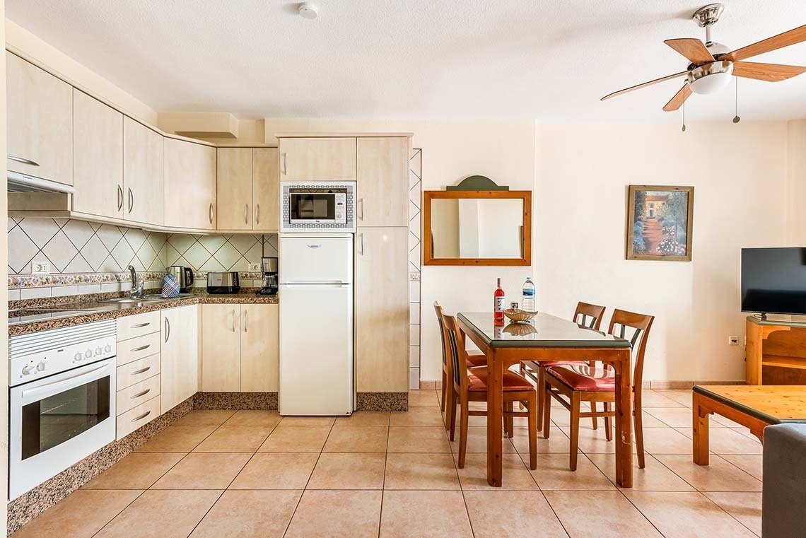 a kitchen with a table and chairs and a ceiling fan