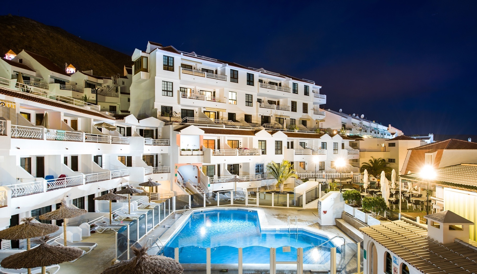 a swimming pool with a canopy bed in front of it