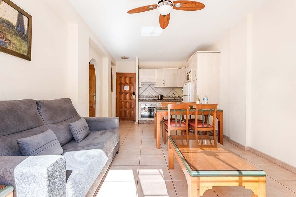 a living room with a couch and a ceiling fan