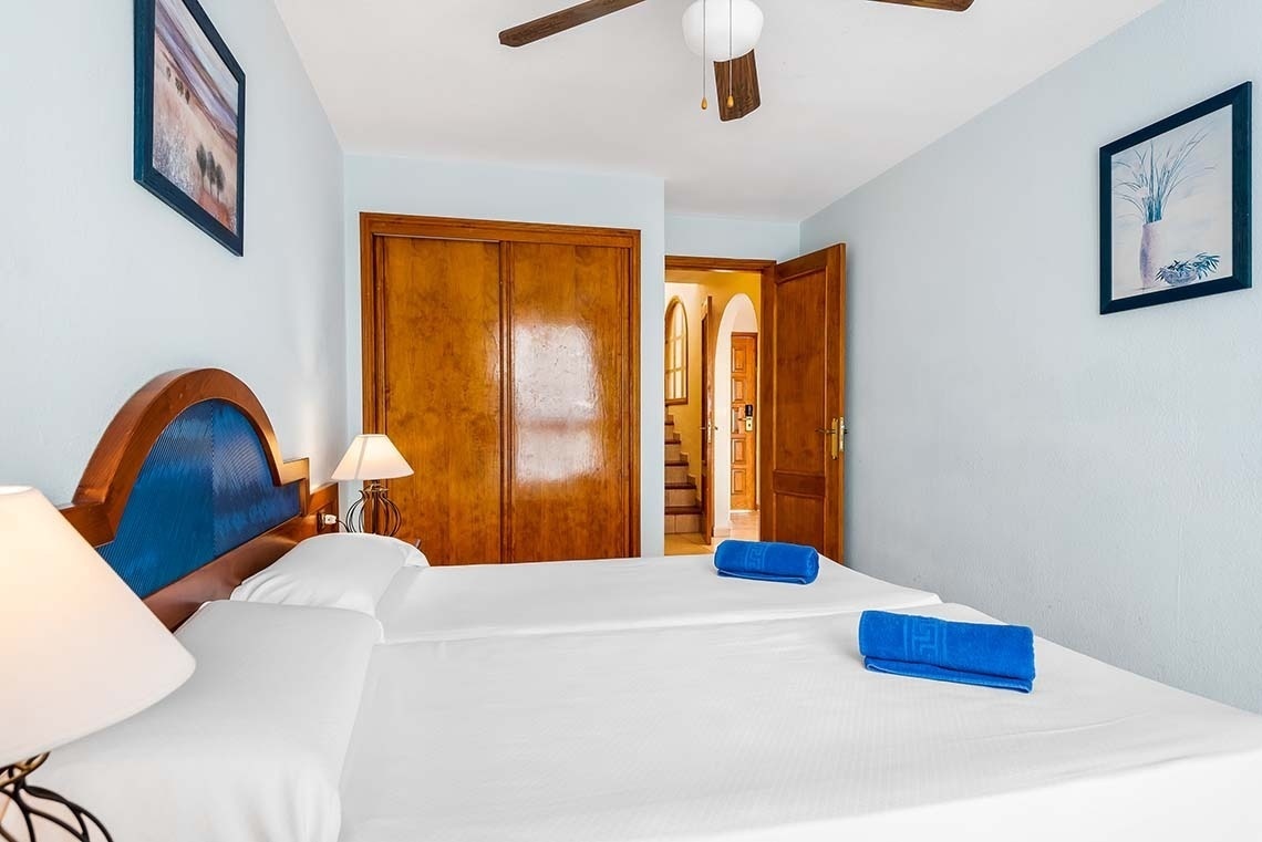 a bedroom with two beds and a ceiling fan