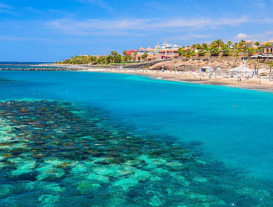a hammock and umbrella on a balcony overlooking the ocean