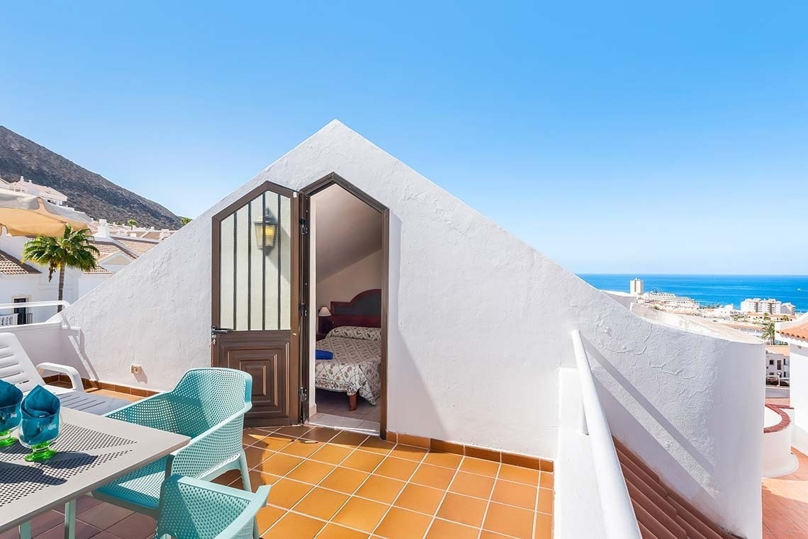 a balcony with a view of the ocean and mountains