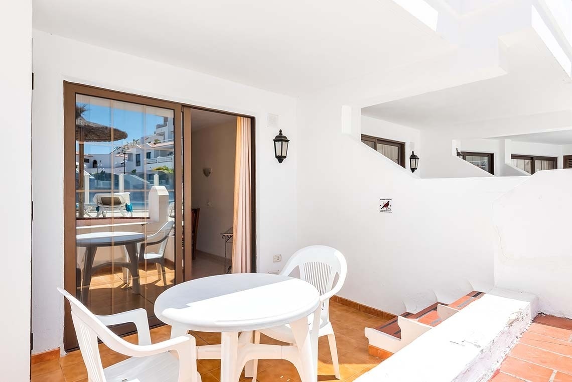 a balcony with a table and chairs and a sign that says no dogs