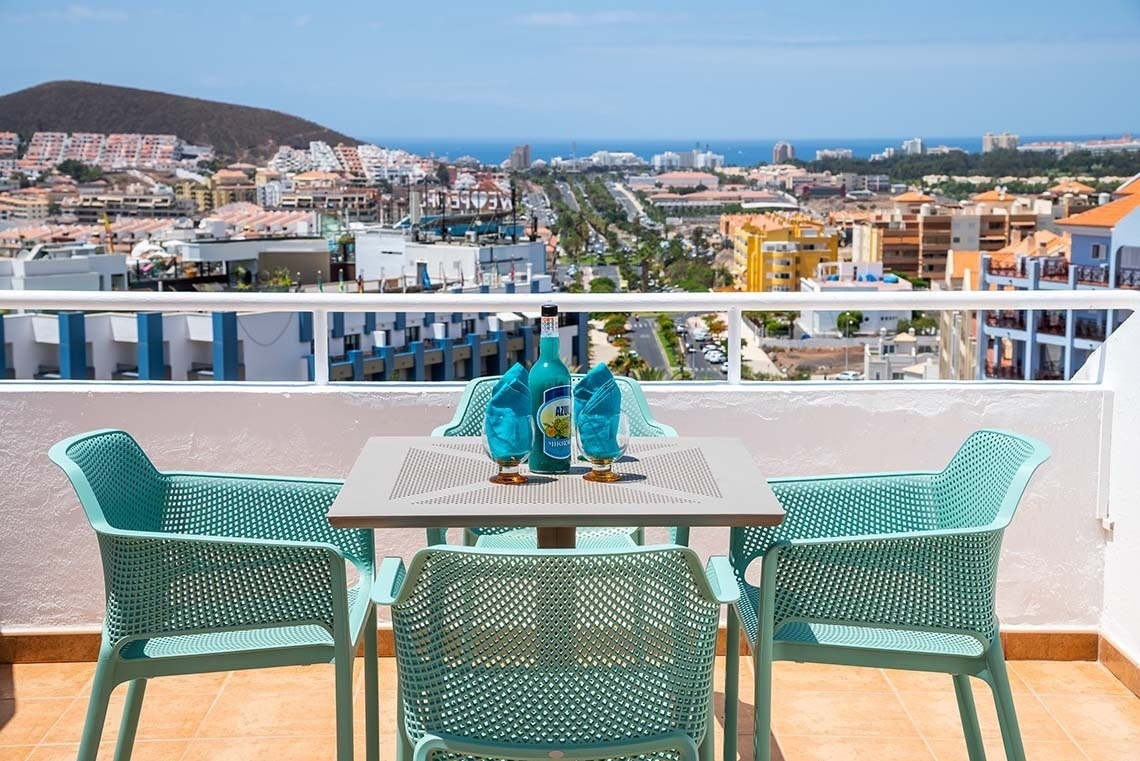 a table and chairs on a balcony overlooking a city