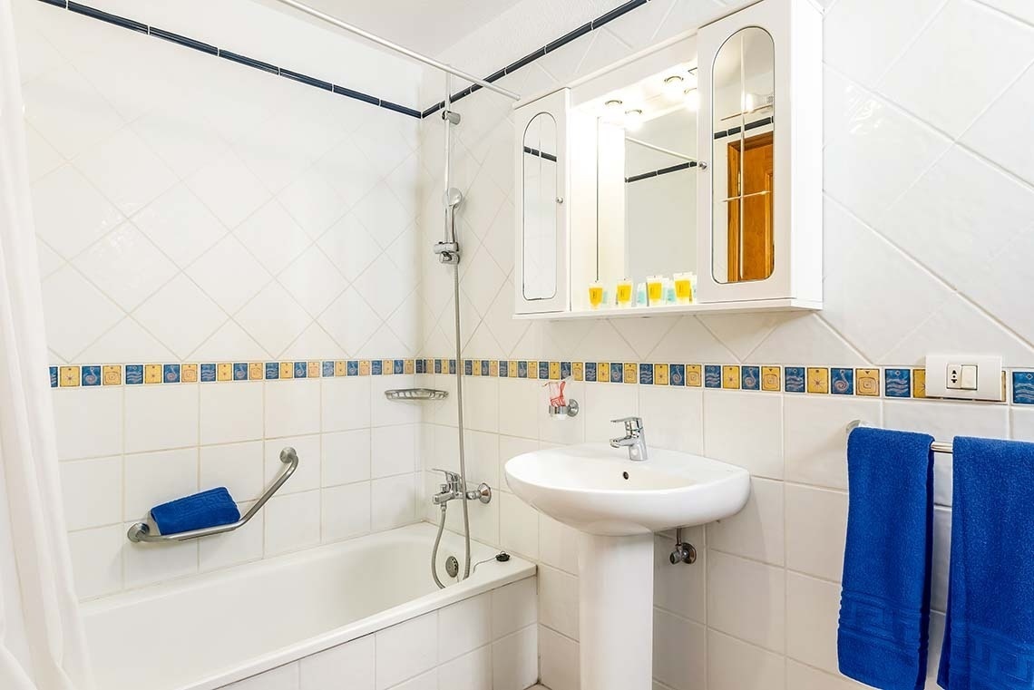 a bathroom with a bathtub sink and mirror