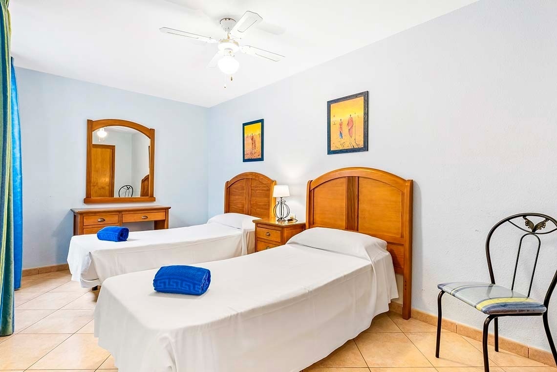 a bedroom with two twin beds and a chair