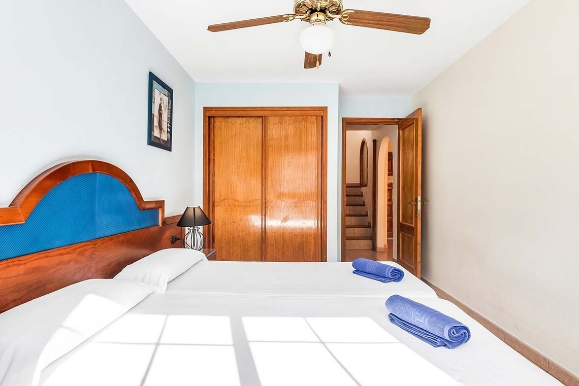 a bedroom with two beds and a ceiling fan